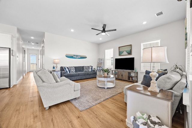 living room with ceiling fan and light wood-type flooring