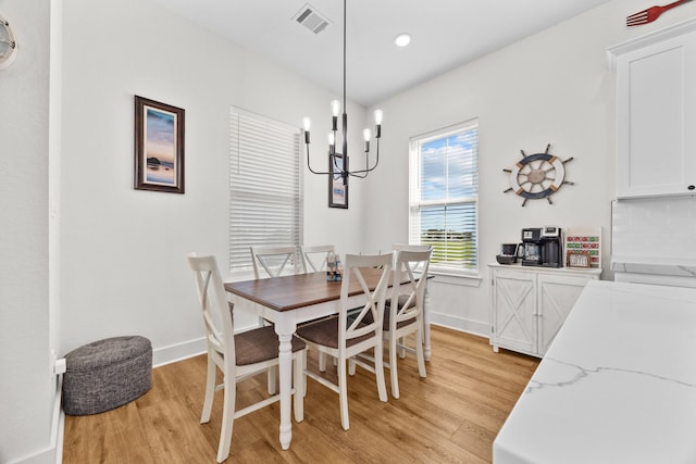 dining area featuring a chandelier and light wood-type flooring