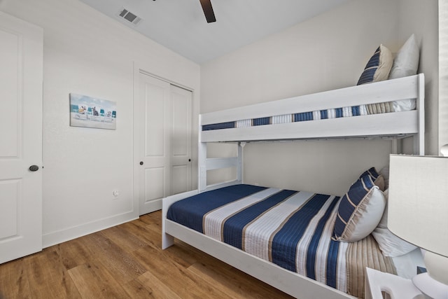 bedroom with wood-type flooring, ceiling fan, and a closet