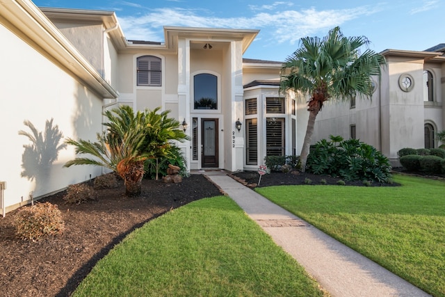 entrance to property featuring a lawn