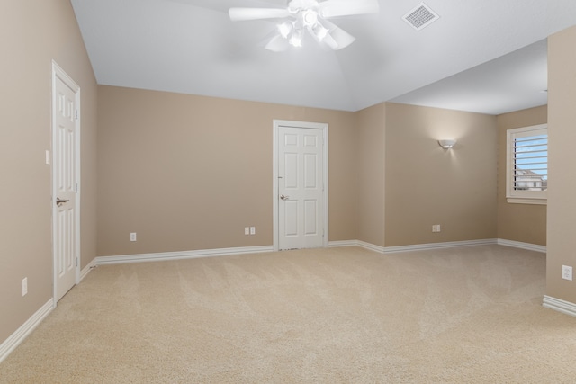 carpeted spare room featuring vaulted ceiling and ceiling fan