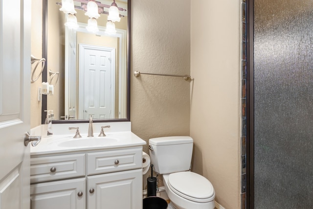 bathroom featuring vanity, toilet, and a shower with door