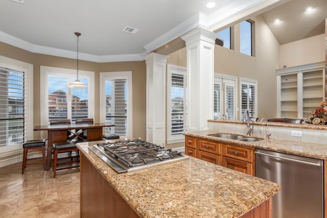 kitchen with ornamental molding, pendant lighting, stainless steel appliances, and sink