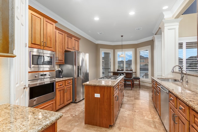 kitchen featuring sink, a center island, stainless steel appliances, crown molding, and decorative light fixtures