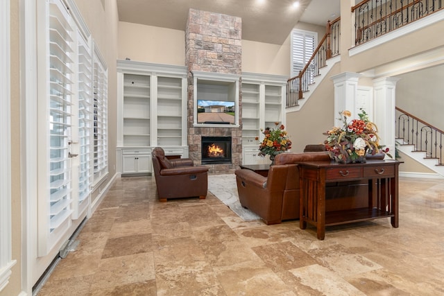 living room featuring a fireplace, a high ceiling, and built in features