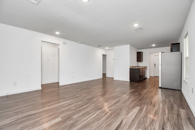 unfurnished living room with dark wood-type flooring