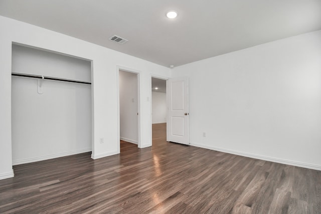 unfurnished bedroom with a closet and dark hardwood / wood-style floors