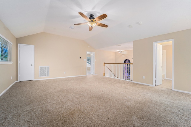 carpeted spare room featuring ceiling fan and vaulted ceiling