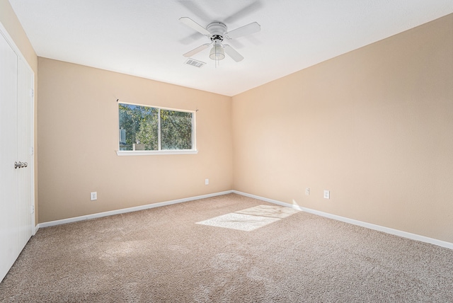 carpeted spare room with ceiling fan