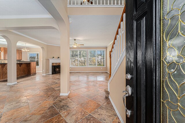 entryway with ceiling fan and ornamental molding