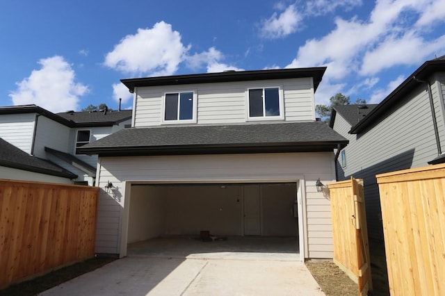 view of front of house with a garage, driveway, a shingled roof, and fence