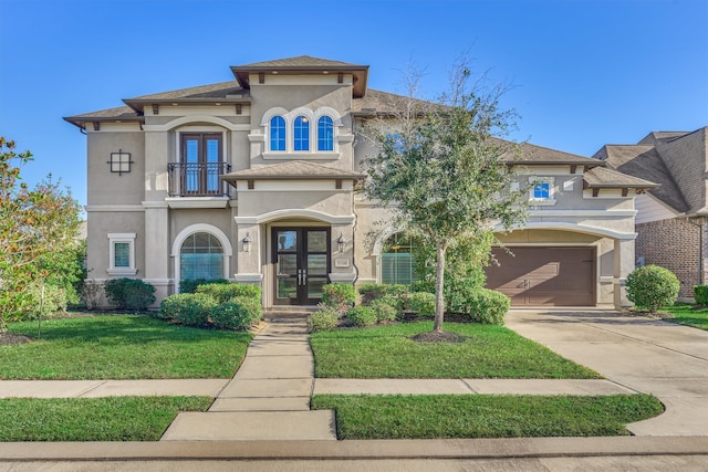 mediterranean / spanish home featuring french doors, a balcony, a front yard, and a garage