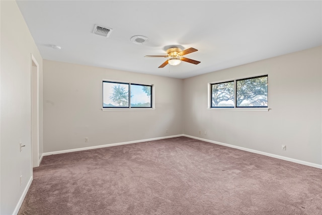 empty room with carpet, plenty of natural light, and ceiling fan