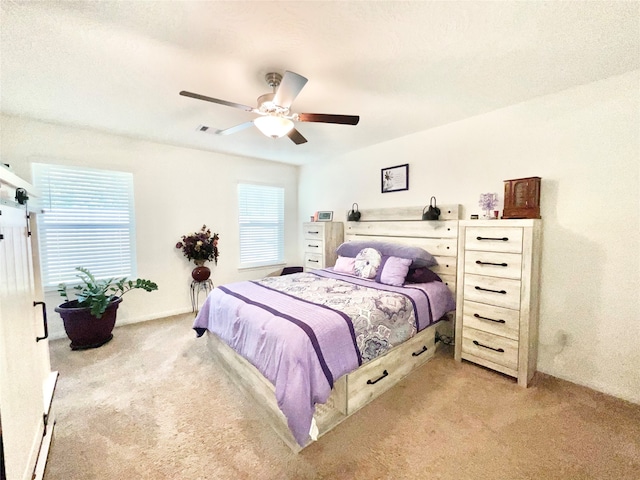 bedroom with ceiling fan and light carpet