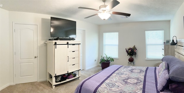 bedroom with multiple windows, ceiling fan, and light colored carpet