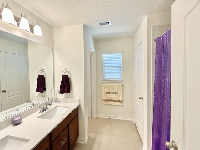 bathroom featuring tile patterned floors, vanity, a shower with curtain, and a textured ceiling