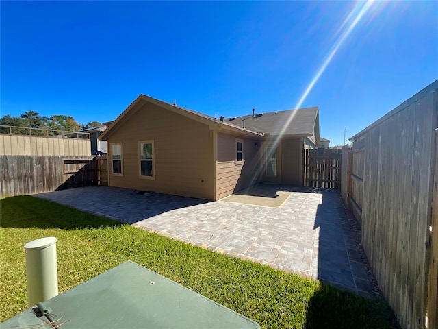 back of house featuring a patio area and a yard