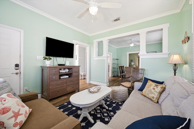 living room featuring hardwood / wood-style flooring, ornate columns, ceiling fan, and ornamental molding