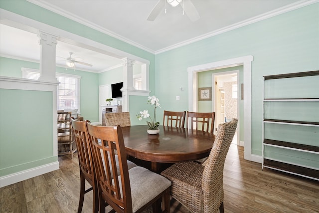 dining room with ceiling fan, dark hardwood / wood-style flooring, ornate columns, and ornamental molding