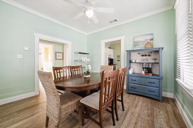 dining room with ceiling fan, hardwood / wood-style floors, and ornamental molding