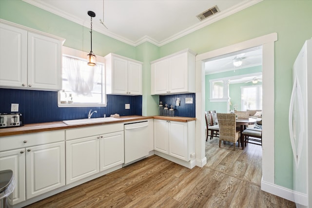 kitchen featuring a healthy amount of sunlight, sink, white appliances, and hanging light fixtures