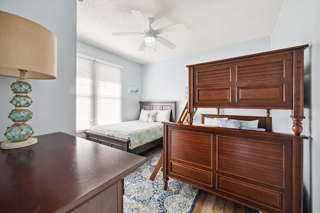 bedroom featuring wood-type flooring, a textured ceiling, and ceiling fan