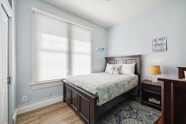 bedroom with multiple windows and light wood-type flooring