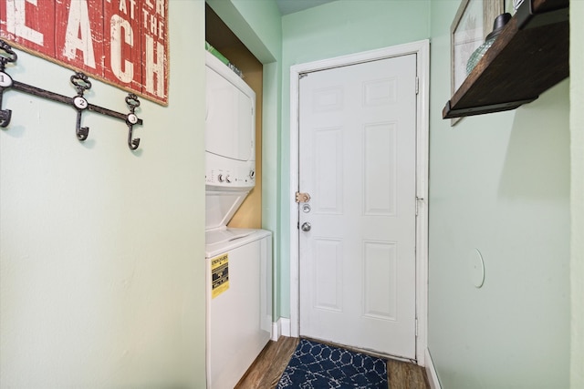 washroom featuring dark hardwood / wood-style floors and stacked washing maching and dryer