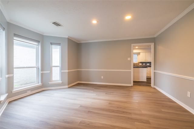 empty room featuring light hardwood / wood-style flooring and ornamental molding