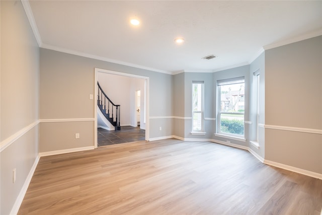 empty room featuring wood-type flooring and crown molding