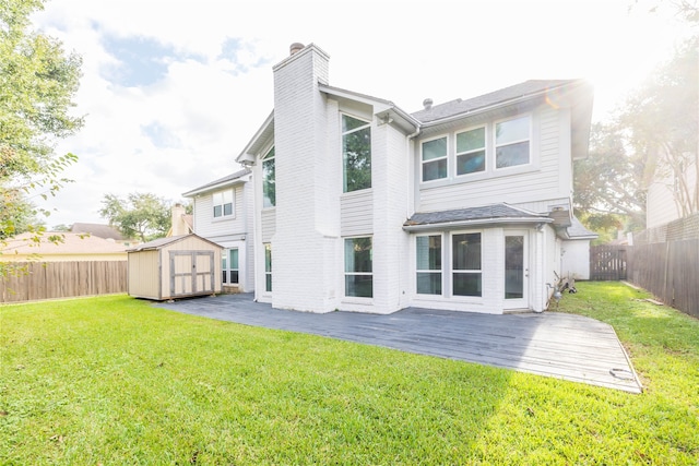 back of property featuring a storage unit, a deck, and a yard