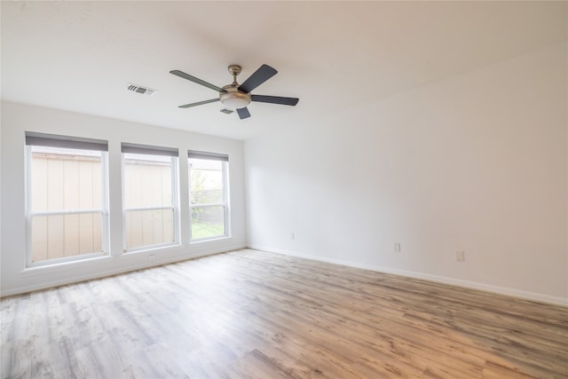 empty room with ceiling fan and light hardwood / wood-style floors