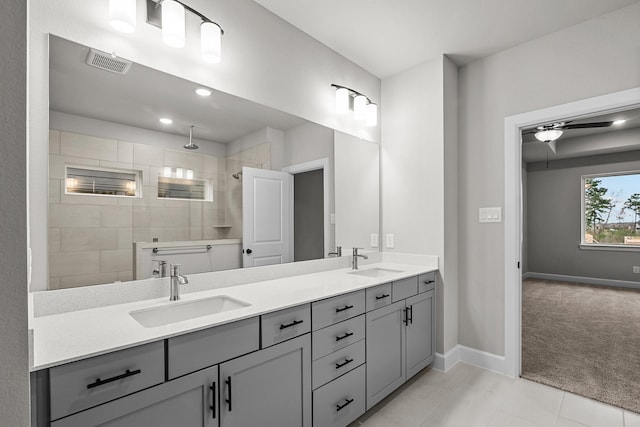 bathroom with a tile shower, vanity, tile patterned floors, and ceiling fan