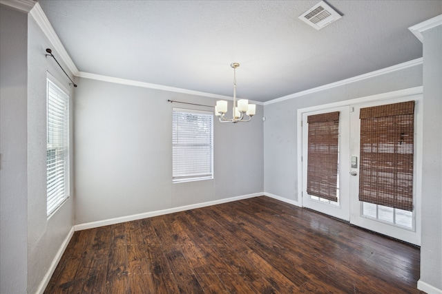 empty room with dark hardwood / wood-style flooring, crown molding, and an inviting chandelier