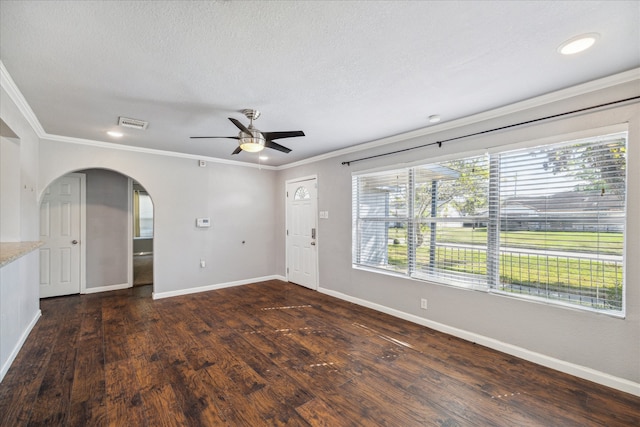 unfurnished room featuring a textured ceiling, ceiling fan, ornamental molding, and dark wood-type flooring