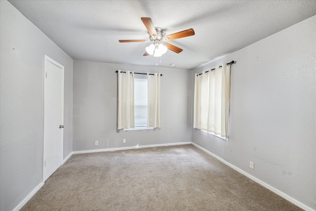 spare room featuring light carpet, ceiling fan, and a textured ceiling