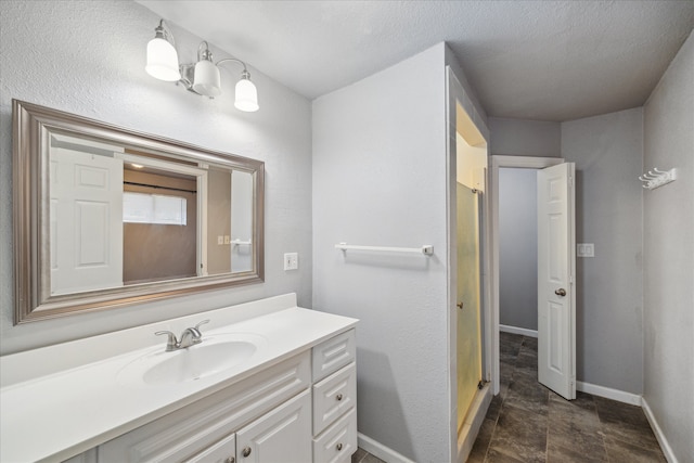 bathroom featuring vanity, a textured ceiling, and a shower with shower door