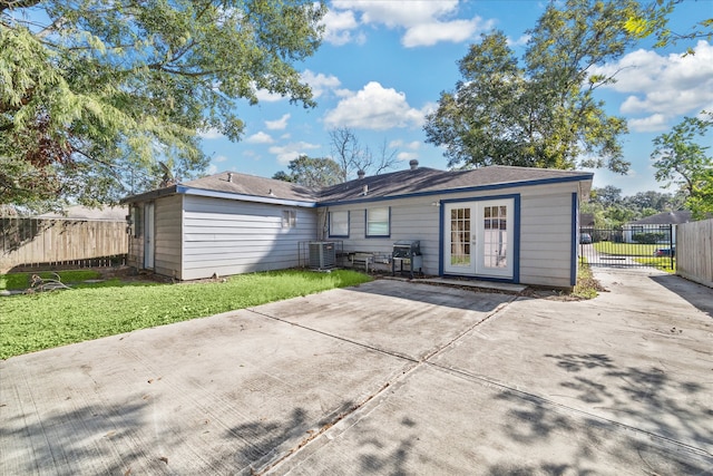 back of property with french doors, a yard, and central air condition unit