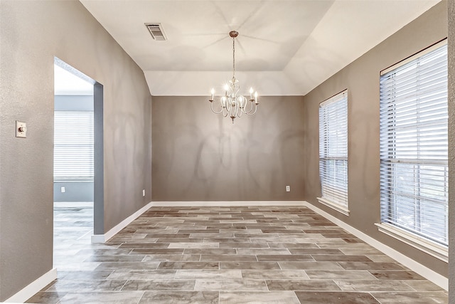 unfurnished dining area with hardwood / wood-style floors and an inviting chandelier