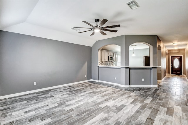 unfurnished living room featuring ceiling fan, wood-type flooring, and lofted ceiling