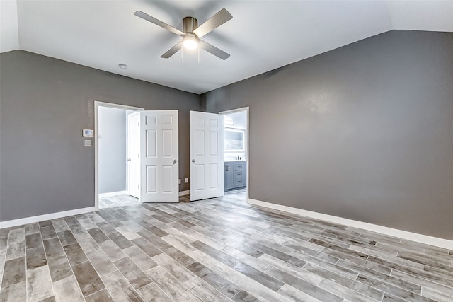 unfurnished room with vaulted ceiling, light hardwood / wood-style flooring, and ceiling fan