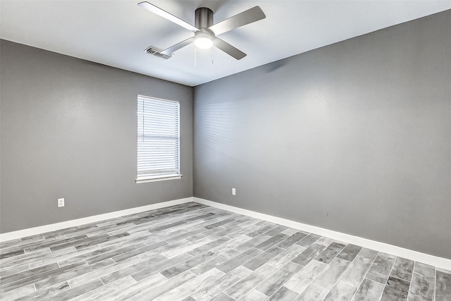 empty room with ceiling fan and light hardwood / wood-style flooring