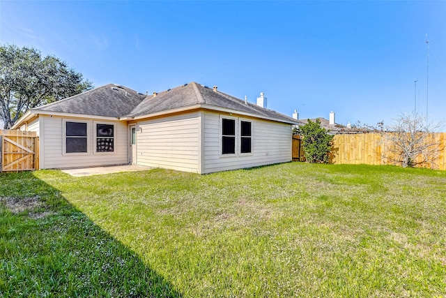 rear view of house featuring a lawn and a patio area