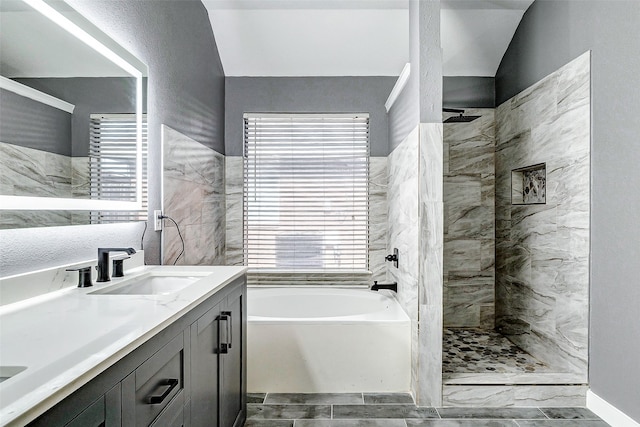 bathroom featuring separate shower and tub, vanity, and vaulted ceiling