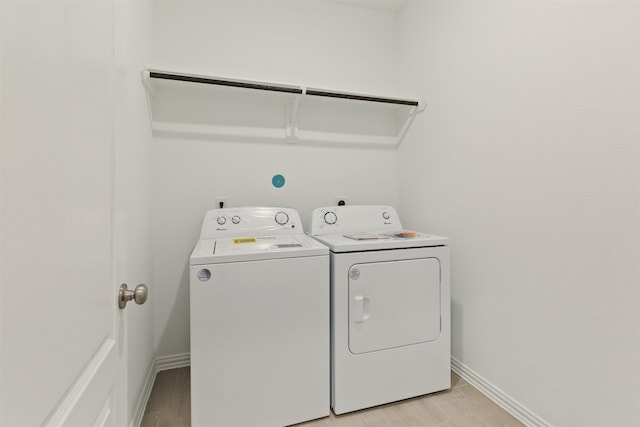 laundry room with washer and dryer and light wood-type flooring