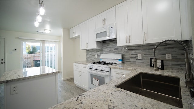 kitchen featuring light hardwood / wood-style flooring, white cabinets, pendant lighting, and white appliances