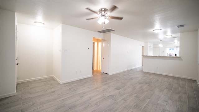 empty room with ceiling fan, a textured ceiling, and light hardwood / wood-style flooring