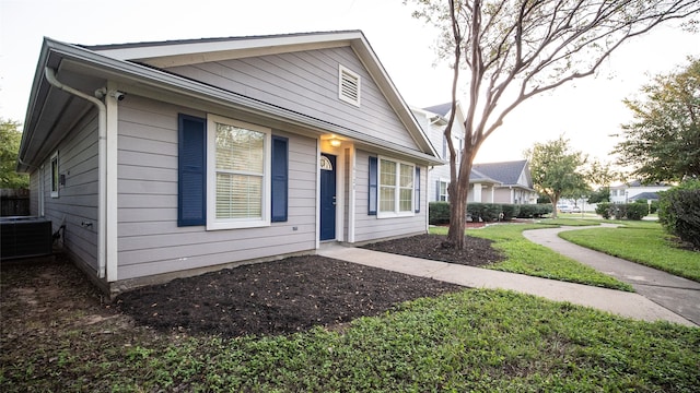 view of front of home featuring cooling unit and a front lawn