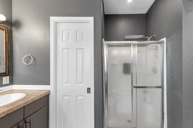 bathroom featuring vanity and a shower with door