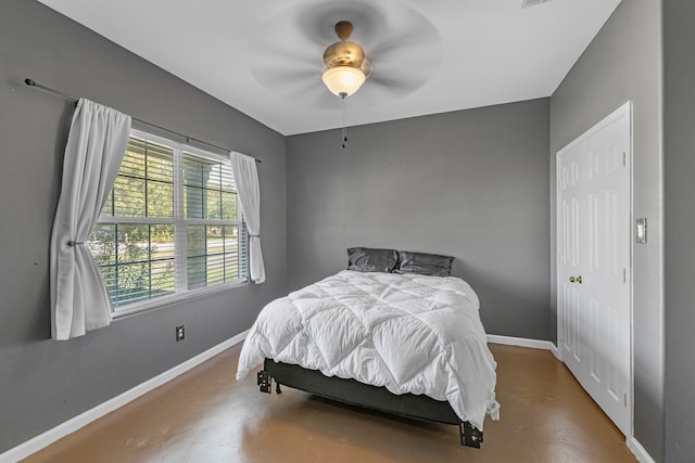 bedroom with ceiling fan and concrete flooring